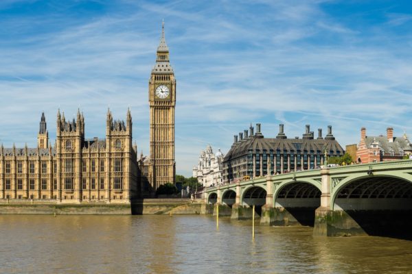 This image shows the iconic Big Ben and the Palace of Westminster next to a bridge over the River Thames on a clear day in London.