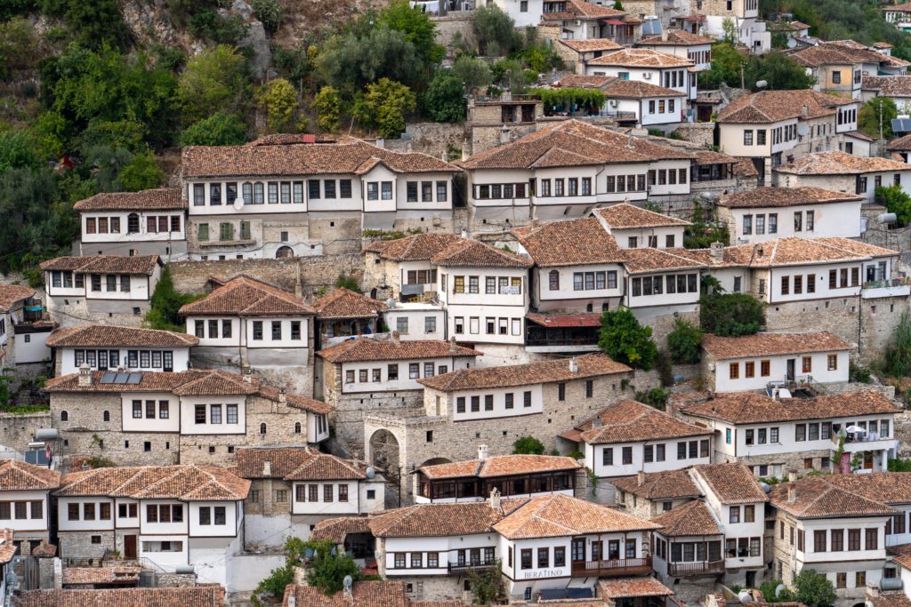 This image shows a dense cluster of traditional stone houses with tiled roofs on a hillside, likely from a historic town in a mountainous region.
