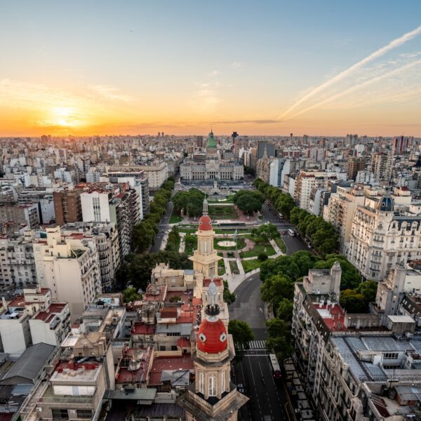 Sunset over Buenos Aires with a view of the Argentine National Congress and surrounding cityscape, featuring lush greenery and historical architecture.